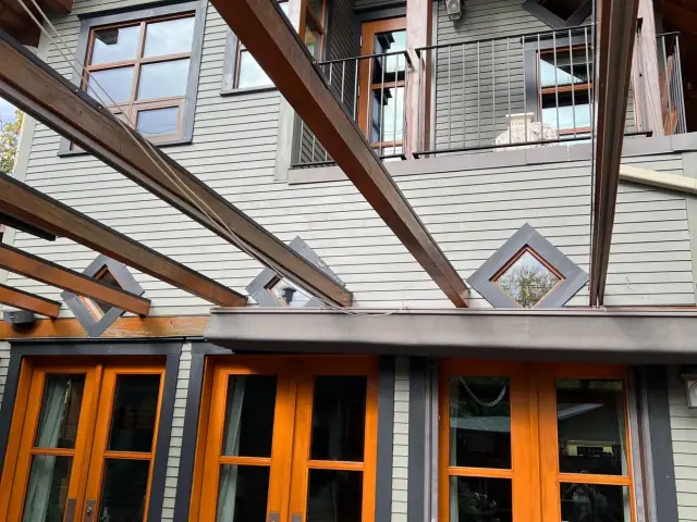 High-end exterior wood project with stained doors, beams and architectural trim