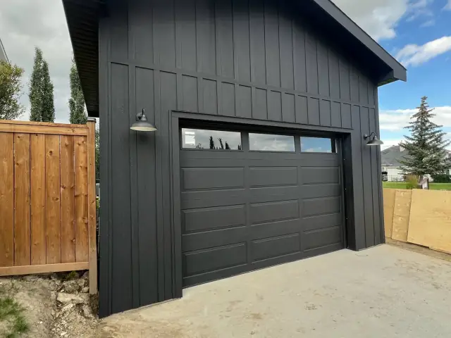 Black detached garage exterior and garage door professionally painted by Dynamic Painting