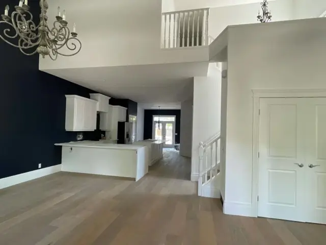 Dramatic dark feature walls with contrasting white trim in a high-ceiling Calgary interior