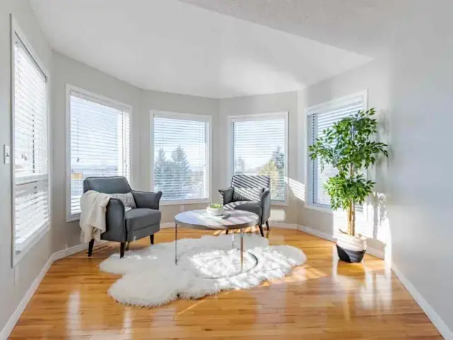 Bright sunroom in the same Calgary home with fresh neutral paint and crisp white window trim