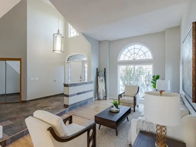 Vaulted Calgary living room from the same finished interior project with clean neutral walls and white trim
