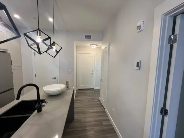 Modern Calgary condo kitchen and hallway with freshly painted walls and sharp white trim