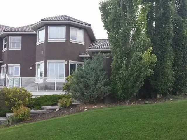 Wide view of a large brown stucco home after exterior repainting by Dynamic Painting
