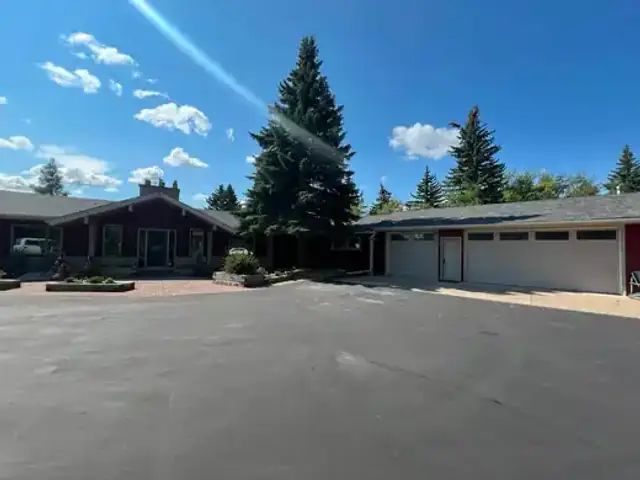 Finished red wood siding home exterior with cream trim and garage elevation
