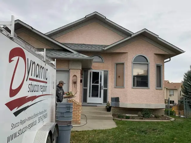 Peach stucco Calgary home before repair and a dark exterior colour transformation