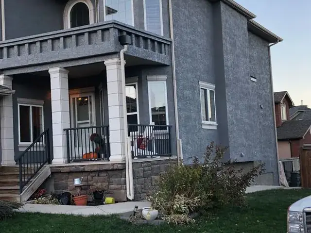 Restored dark grey stucco exterior after graffiti repair and professional repainting