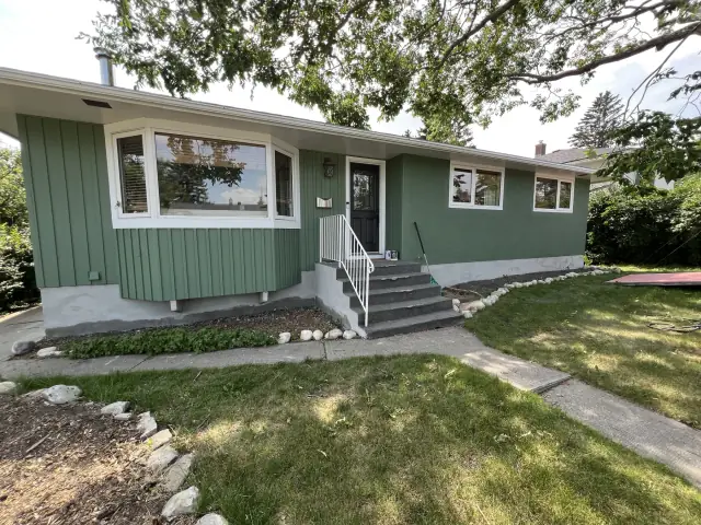 Green Calgary bungalow with freshly painted stucco and coordinating exterior siding
