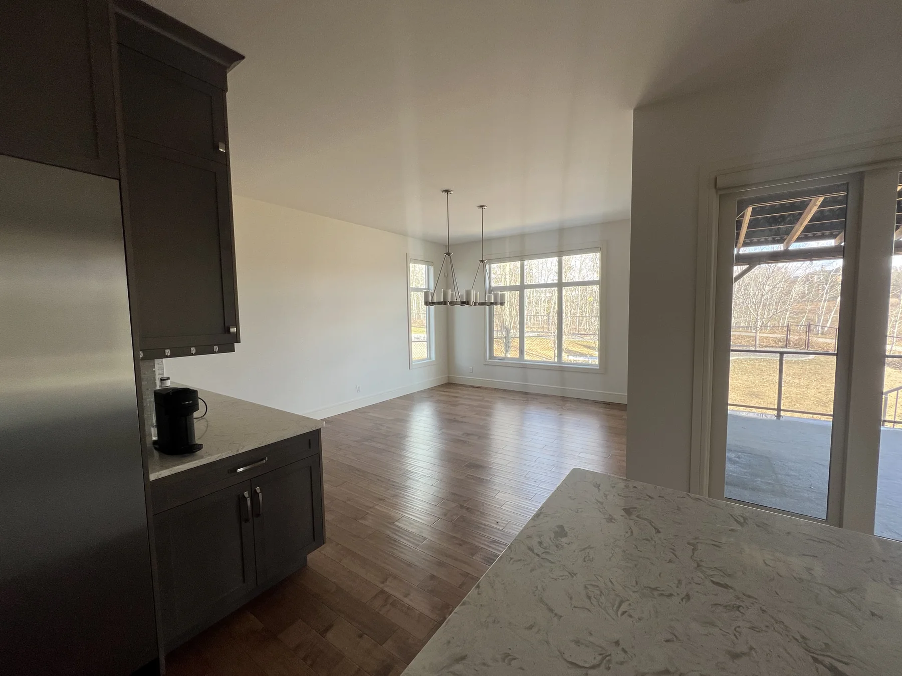 Bright finished open-concept Calgary home interior with clean white walls and warm flooring