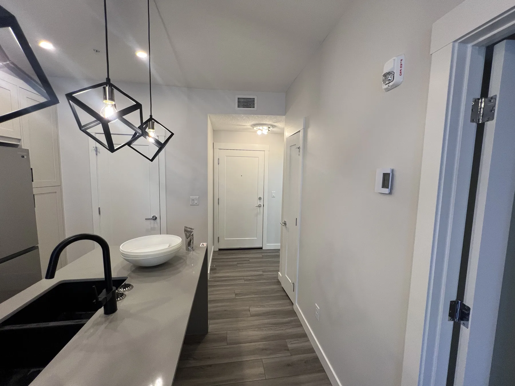 Modern Calgary condo kitchen and hallway with freshly painted walls and sharp white trim