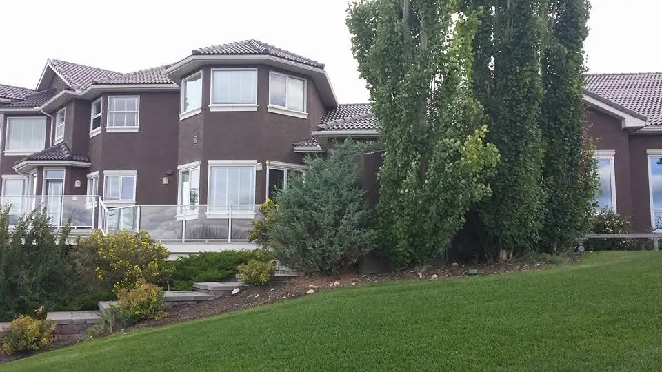 Wide view of a large brown stucco home after exterior repainting by Dynamic Painting