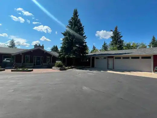 Finished red wood siding home exterior with cream trim and garage elevation