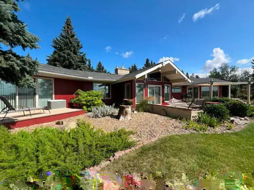 Finished red wood siding exterior with cream trim and landscaped Calgary-area backyard