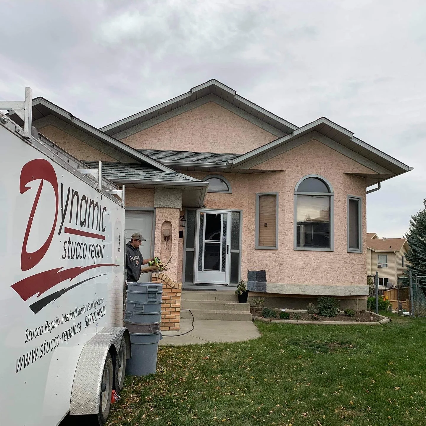 Peach stucco Calgary home before repair and a dark exterior colour transformation