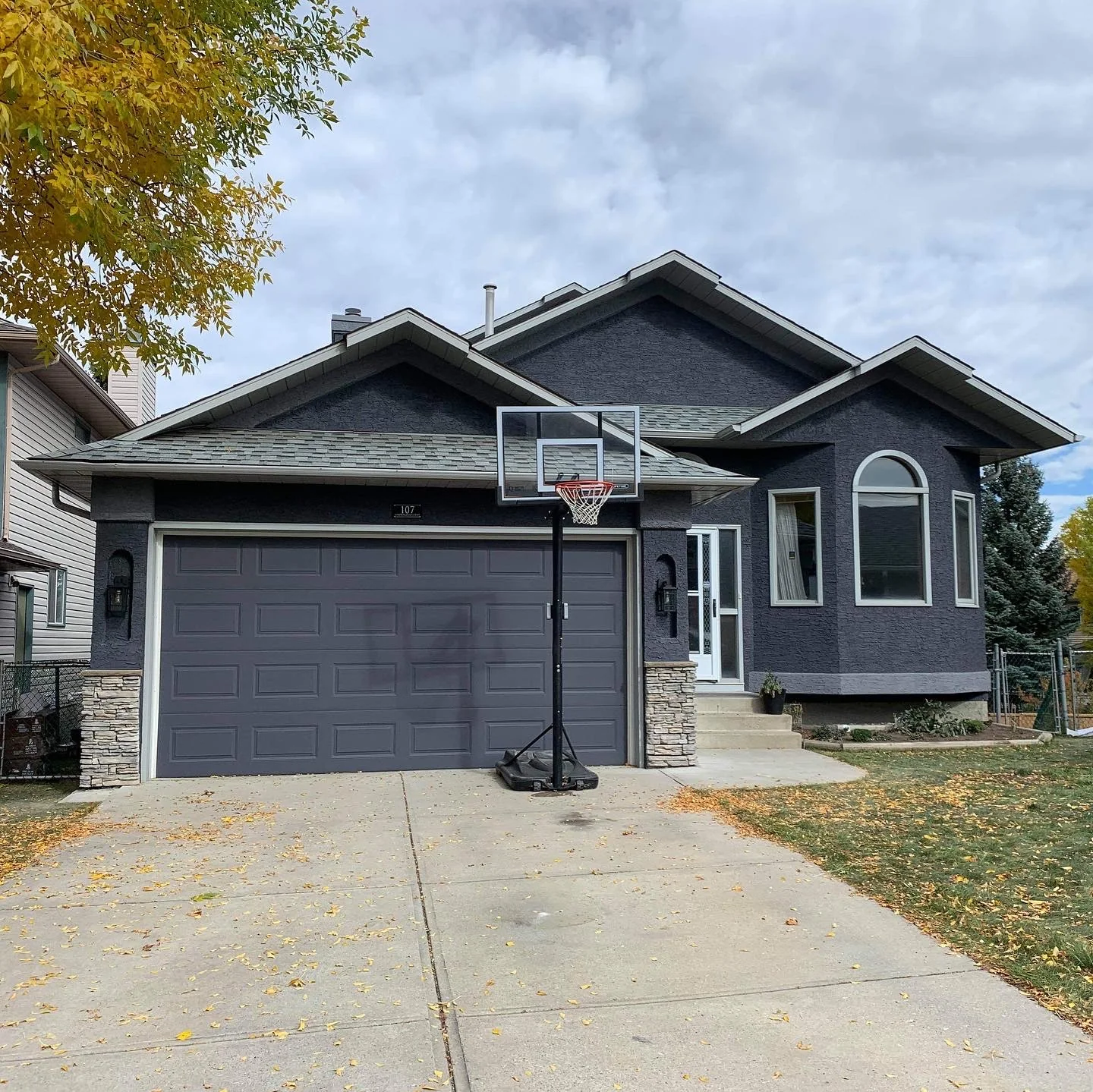 Finished charcoal grey Calgary stucco home after professional repair and painting