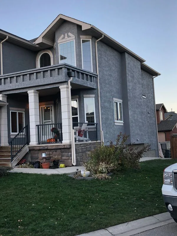 Restored dark grey stucco exterior after graffiti repair and professional repainting