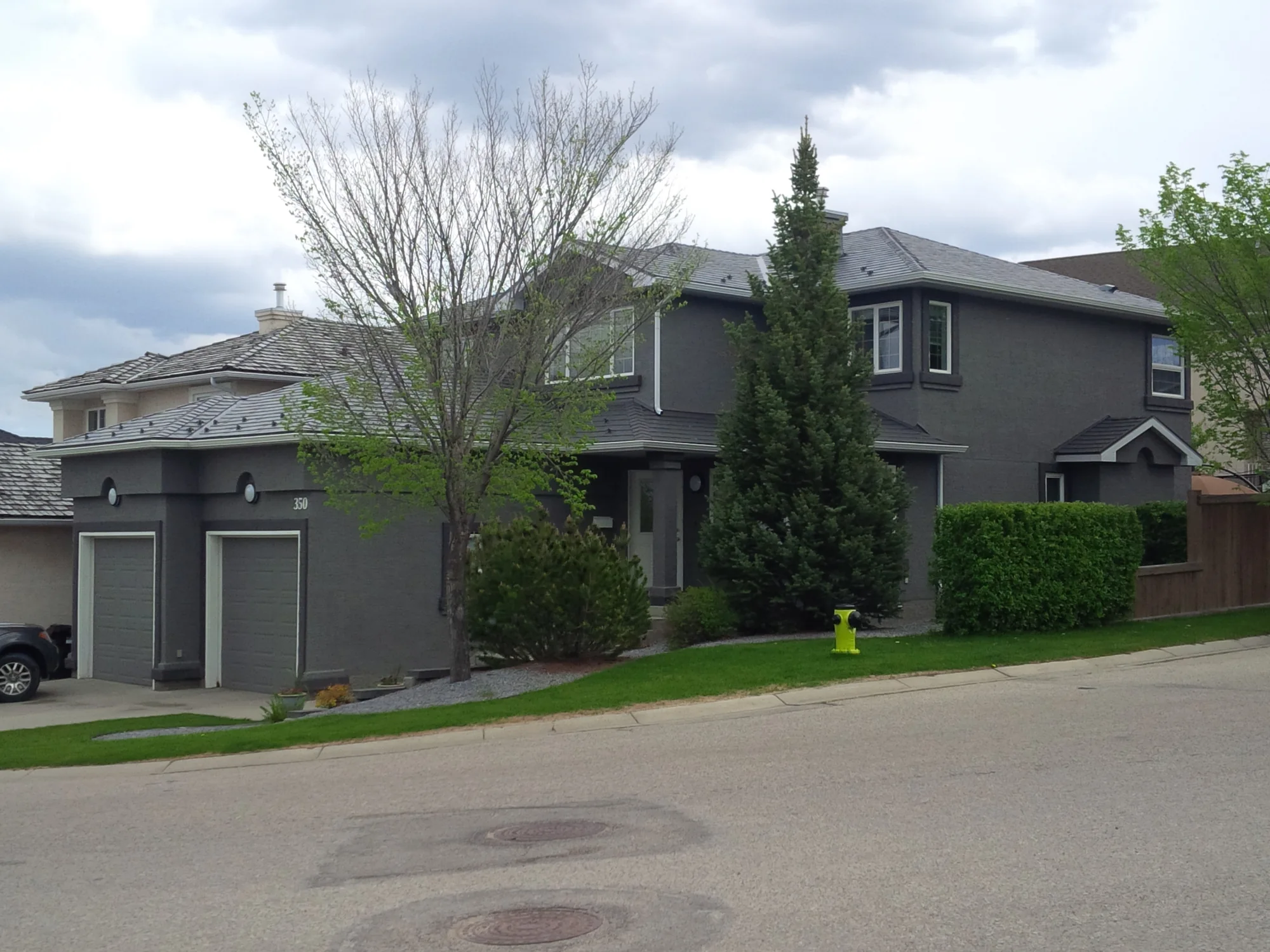 Large stucco home after a dramatic charcoal grey exterior painting transformation