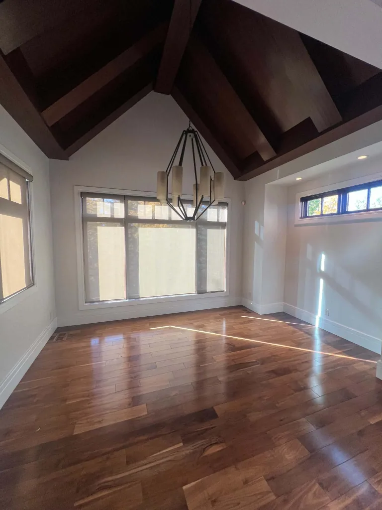 The same beamed room after repainting, with Dove Wing walls, Simply White window trim and the retained wood ceiling
