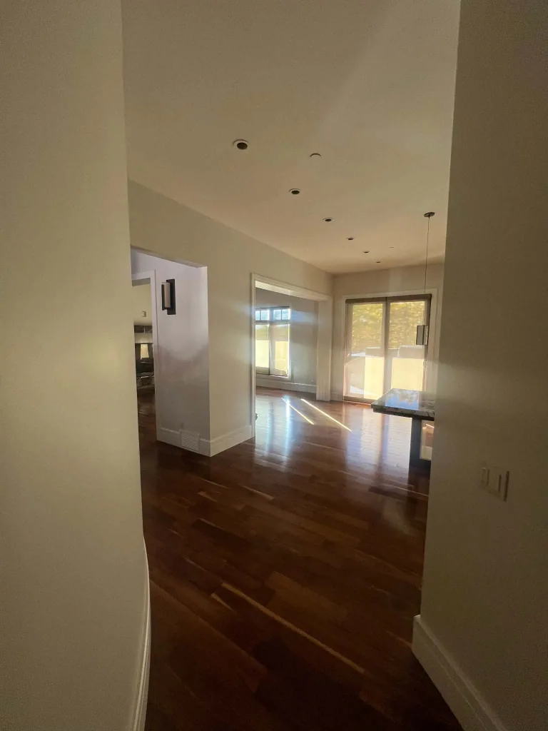 Finished main-floor hallway with light walls and white-trimmed openings into adjoining rooms