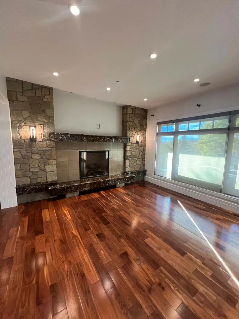 Finished main-floor living room with Dove Wing walls, white trim, a stone fireplace and wood flooring