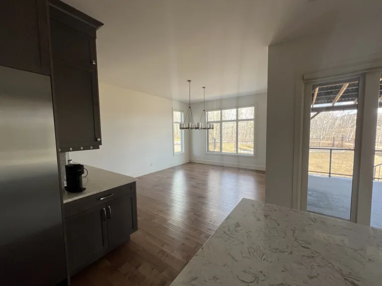 Completed Calgary dining-area wall painting beside dark kitchen cabinets and warm flooring