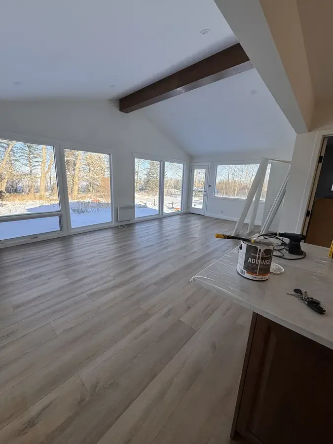 Vaulted interior with white walls, a white ceiling and an exposed dark beam