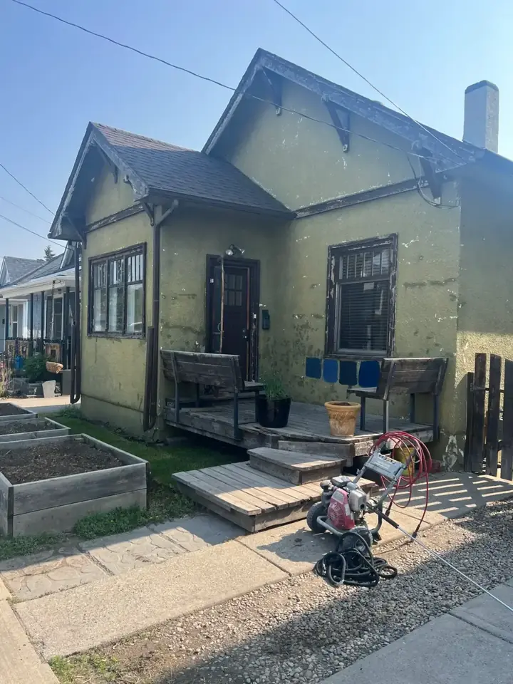Weathered light stucco house before painting